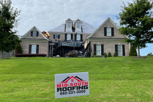 A sign that says mid south roofing in front of a house.