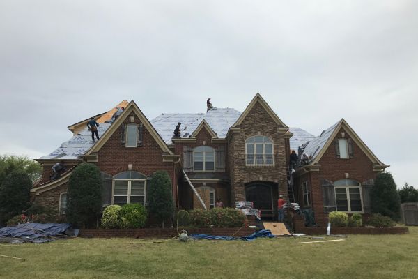 A large house with some people working on it