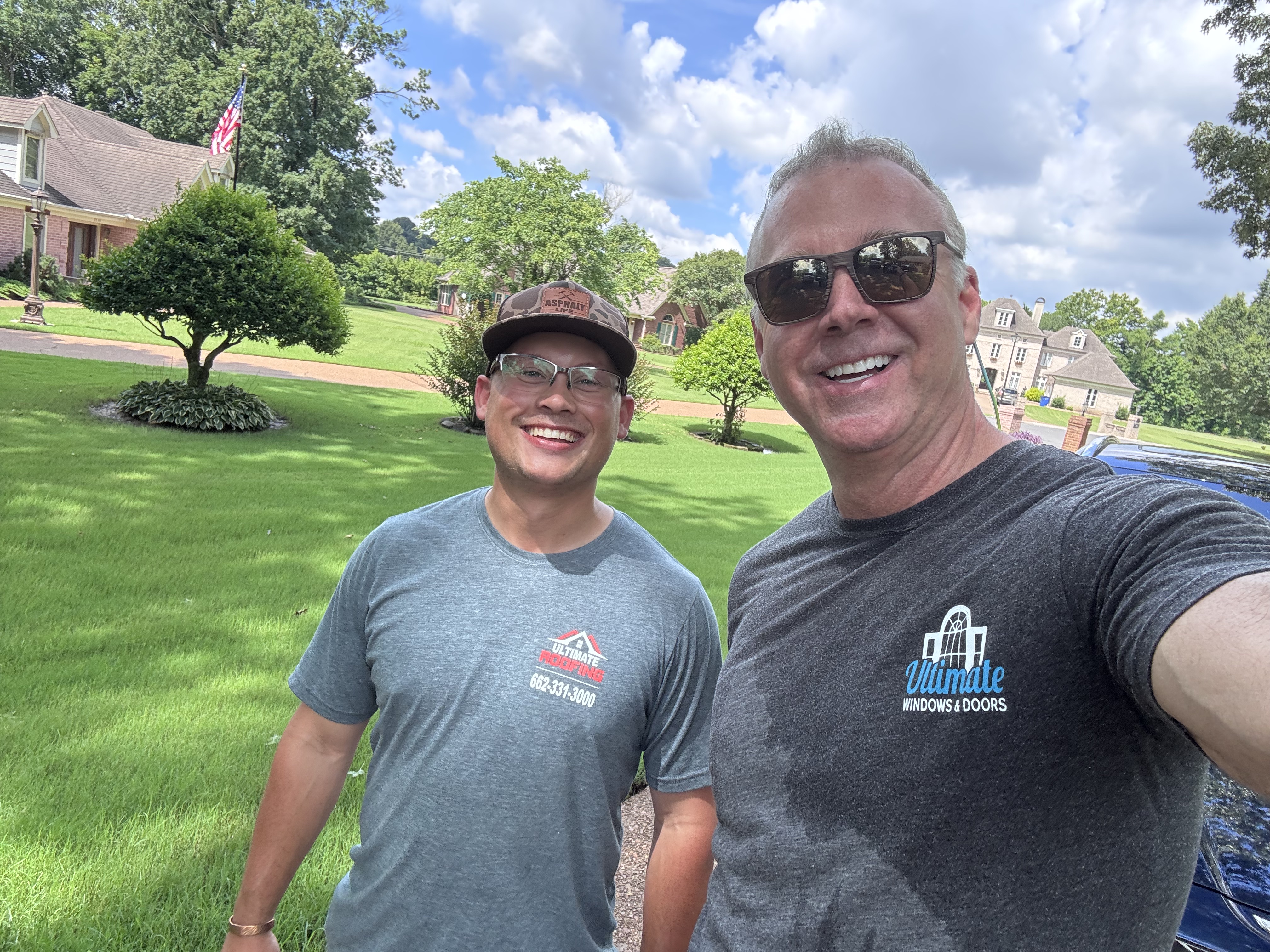 Owner Paul Ollar with team member in Ultimate Roofing shirts